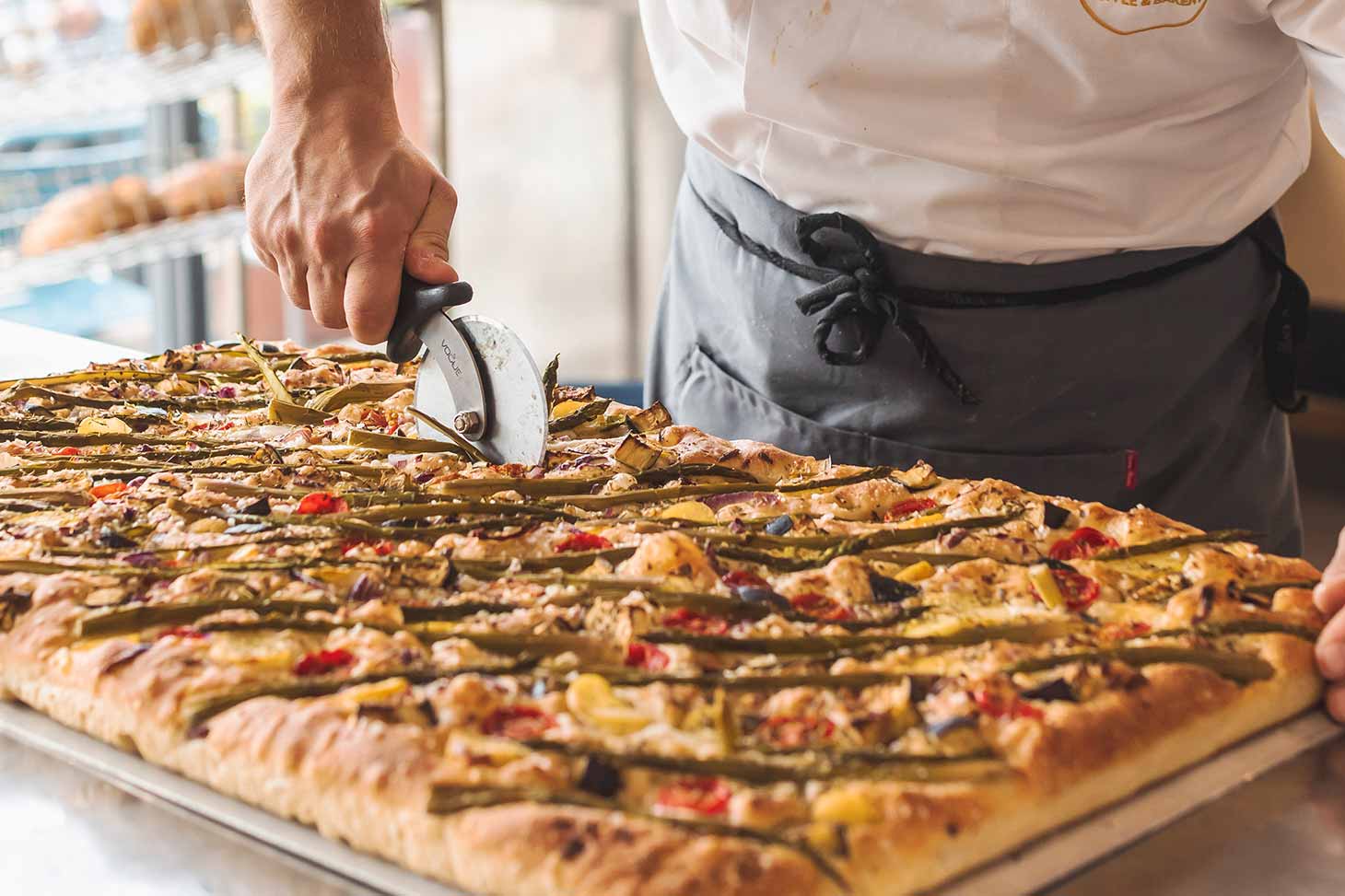 Freshly baked pizza being sliced